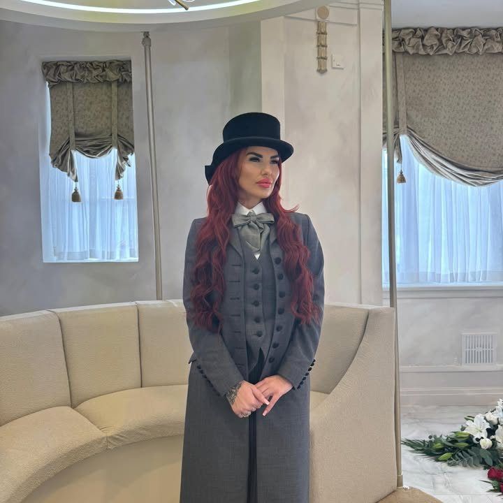 A Butterflies Rising funeral director in a grey tailcoat and top hat